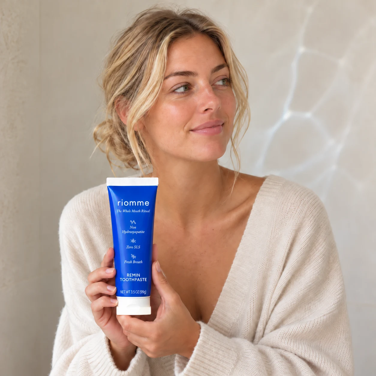 A woman holding Remin Toothpaste